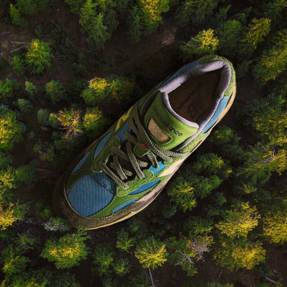 Two people posing indoors against a textured backdrop, wearing casual athletic outfits and sneakers. 
